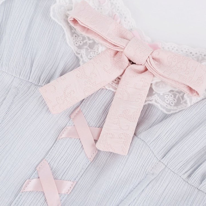 Top corset bleu manches papillon à nœuds roses